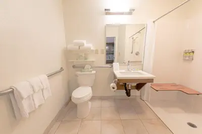 a white bathroom with a toilet and a sink at Candlewood Suites-West Springfield by IHG in West Springfield