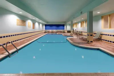 a large indoor pool with blue lights in a hotel room at Candlewood Suites-West Springfield by IHG in West Springfield