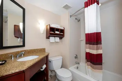 a bathroom with a sink and a toilet and a mirror at Red Roof Inn Meriden - CT in Meriden