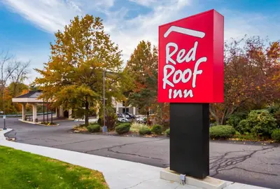 a red root sign on a pole on a street at Red Roof Inn Meriden - CT in Meriden
