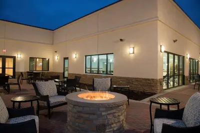 a patio with a fire pit and chairs and tables at DoubleTree by Hilton Schenectady in Schenectady