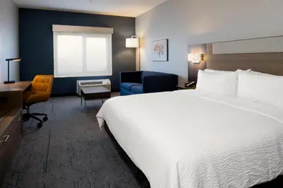 a hotel room with a large white bed and a desk at Holiday Inn Express & Suites Albany Airport Area - Latham by IHG in Latham