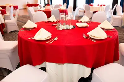 a table with a red table cloth and white chairs at Holiday Inn Express & Suites Albany Airport Area - Latham by IHG in Latham