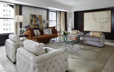 a living room with two couches and a table at The Peninsula New York in New York