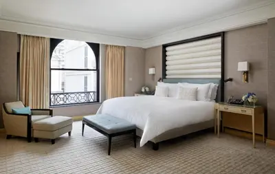 a bedroom with a large white bed and a window at The Peninsula New York in New York