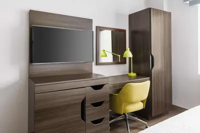 a bedroom with a desk with a tv and a yellow chair at Hampton Inn Manhattan-35th St Empire State Bldg in New York