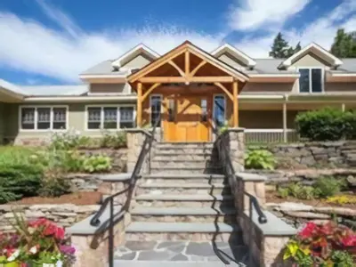a home with a porch with stairs leading to the front door at The Inn at Quail Run in Wilmington