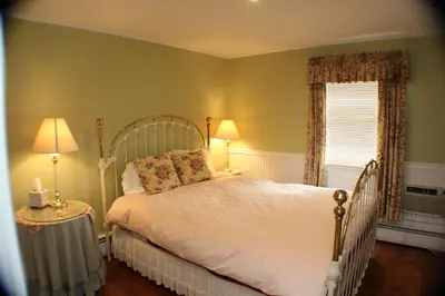 a bedroom with a white bed and a window at The Inn at Quail Run in Wilmington