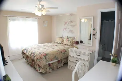 a bedroom with a bed and a dresser and a mirror at The Inn at Quail Run in Wilmington