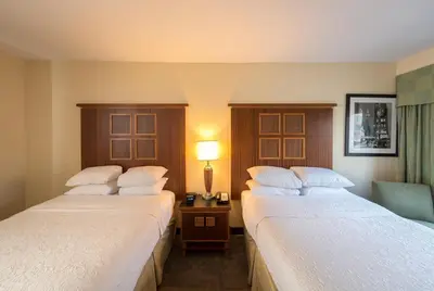 a hotel room with two beds and a table with a lamp at SoHo 54 in New York