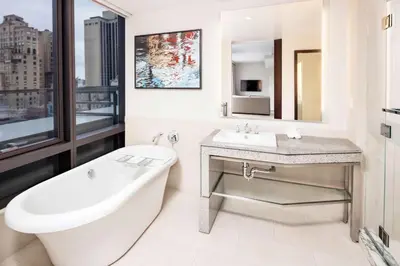 a bathroom with a bath tub and a sink and a bath tub at Hilton Club West 57th Street New York in New York