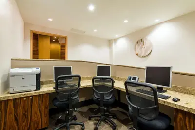 a waiting room with chairs and a desk with two monitors at Hilton Club West 57th Street New York in New York