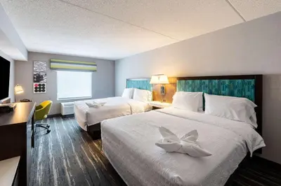 a hotel room with two beds with a flower on them at Hampton Inn & Suites Poughkeepsie in Spackenkill