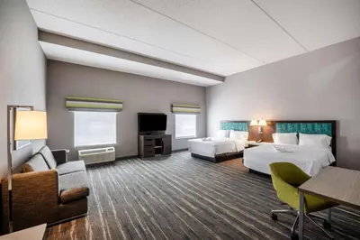 a hotel room with two beds and a flat screen tv at Hampton Inn & Suites Poughkeepsie in Spackenkill