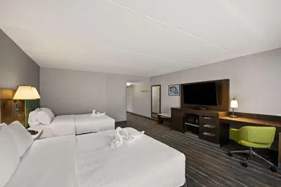 a hotel room with two beds and a flat screen tv at Hampton Inn & Suites Poughkeepsie in Spackenkill