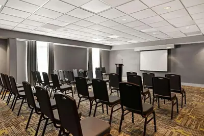 a conference room with chairs and a screen at Hampton Inn & Suites Poughkeepsie in Spackenkill