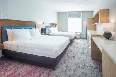 a hotel room with two beds and a kitchen at Home2 Suites by Hilton Saratoga Malta in Malta