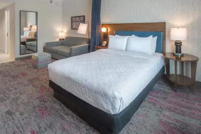 a hotel room with a bed and a chair at Home2 Suites by Hilton Saratoga Malta in Malta