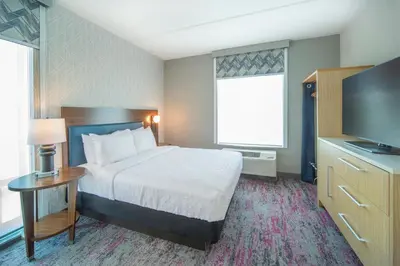 a hotel room with a bed and a flat screen tv at Home2 Suites by Hilton Saratoga Malta in Malta