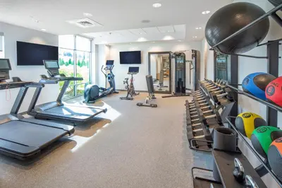 a gym with treadmills and exercise bikes in it at Home2 Suites by Hilton Saratoga Malta in Malta