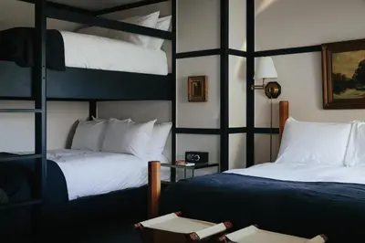 a bedroom with two bunk beds and a table at Brentwood Hotel in Saratoga Springs