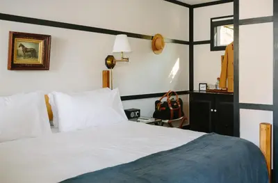 a hotel room with a bed and a mirror at Brentwood Hotel in Saratoga Springs