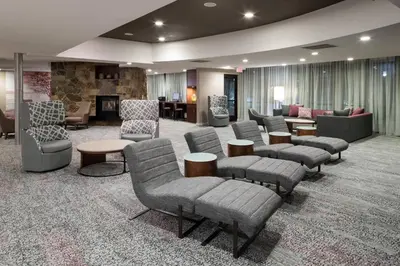 a waiting room with couches and chairs and a fireplace at Courtyard by Marriott West Orange in West Orange