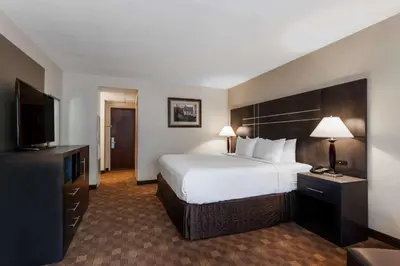 a hotel room with a large bed and a flat screen tv at Wyndham Southbury in Southbury