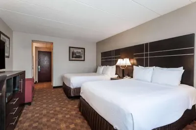 a hotel room with two beds and a television at Wyndham Southbury in Southbury