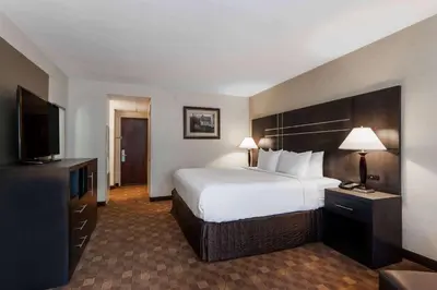 a hotel room with a large bed and a flat screen tv at Wyndham Southbury in Southbury