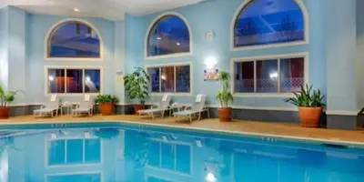 a swimming pool in a hotel with chairs at Wyndham Southbury in Southbury