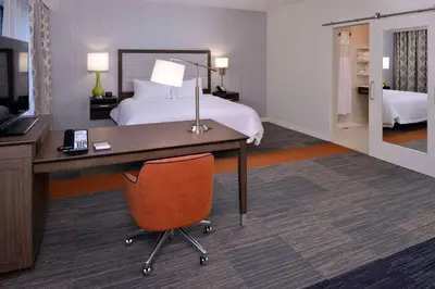 a hotel room with a bed and a desk with a computer at Hampton Inn & Suites Albany-East Greenbush, NY in East Greenbush