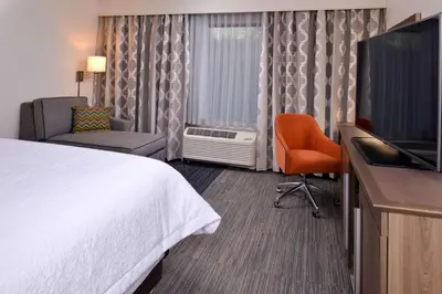 a hotel room with a bed and a flat screen tv at Hampton Inn & Suites Albany-East Greenbush, NY in East Greenbush