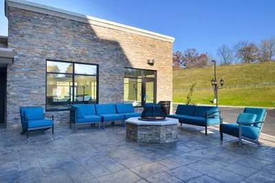 a patio with blue chairs and a fire pit at Hampton Inn & Suites Albany-East Greenbush, NY in East Greenbush