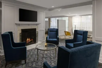 a living room with two chairs and a fireplace at Courtyard New Haven at Yale in New Haven