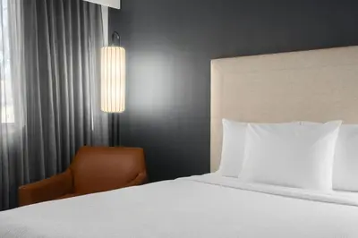 a hotel room with a bed and a chair at Courtyard New Haven at Yale in New Haven