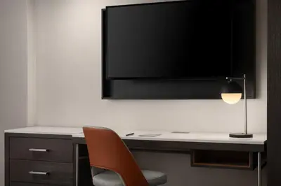 a desk with a chair and a television on a wall at Courtyard New Haven at Yale in New Haven