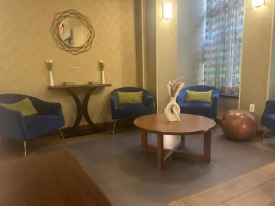 a waiting room with a table and chairs and a mirror at Fairfield Inn & Suites by Marriott New York Manhattan/Fifth Avenue in New York