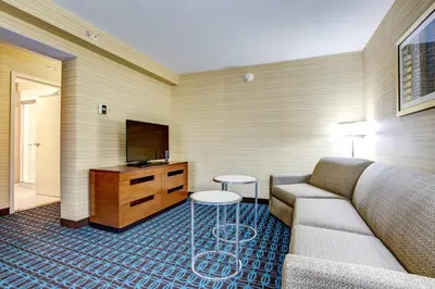 a living room with a couch and a flat screen tv at Fairfield Inn & Suites by Marriott Springfield Holyoke in Holyoke