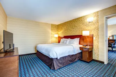 a hotel room with a large bed and a television at Fairfield Inn & Suites by Marriott Springfield Holyoke in Holyoke