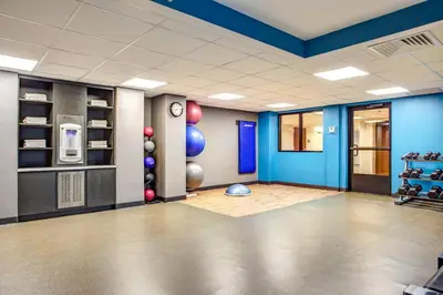a room with a gym with blue walls at Fairfield Inn & Suites by Marriott Springfield Holyoke in Holyoke