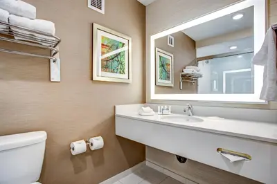 a bathroom with a sink and a toilet and a mirror at Fairfield Inn & Suites by Marriott Springfield Holyoke in Holyoke