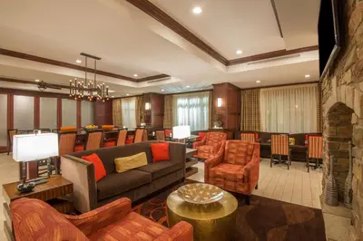 a living room with a couch and chairs and a bar at Hampton Inn Kingston in Kingston