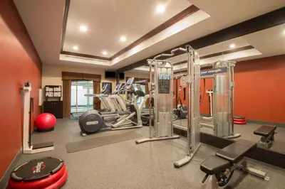 a gym with cardio equipment in a room with orange walls at Hampton Inn Kingston in Kingston