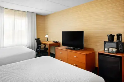 a hotel room with two beds and a flat screen tv at Fairfield Inn and Suites by Marriott Plainville in Plainville