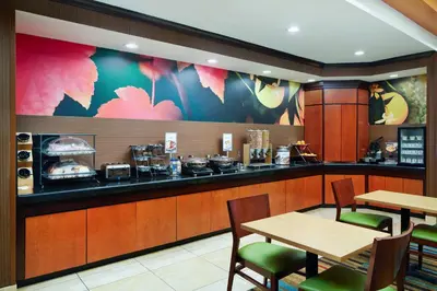 a restaurant with two tables and a counter with food at Fairfield Inn and Suites by Marriott Plainville in Plainville