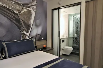a bedroom with a bed and a bathroom with a toilet at Carnegie Hotel in New York