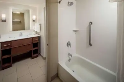 a bathroom with a tub and a sink and a mirror at Homewood Suites by Hilton Wallingford-Meriden in Wallingford