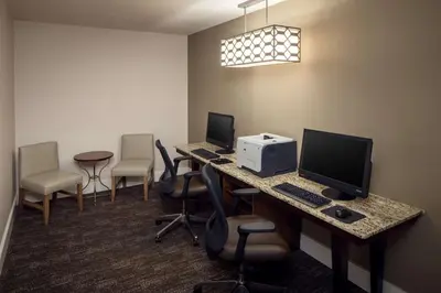 a conference room with a desk with a computer and chairs at Homewood Suites by Hilton Wallingford-Meriden in Wallingford