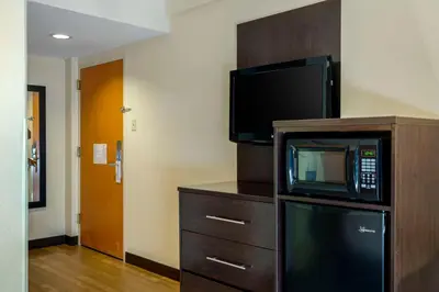 a microwave sitting on top of a dresser with a tv at The Capitol Hotel in Hartford